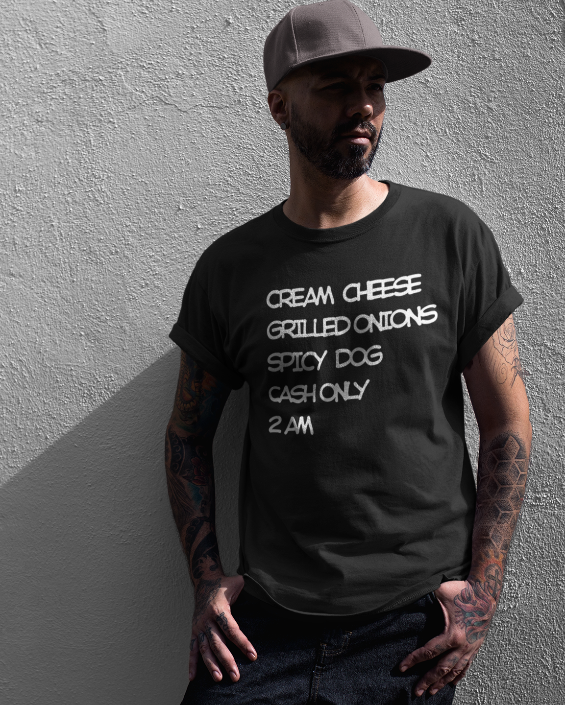Man wearing a black t-shirt with Seattle Dog recipe against a gray wall