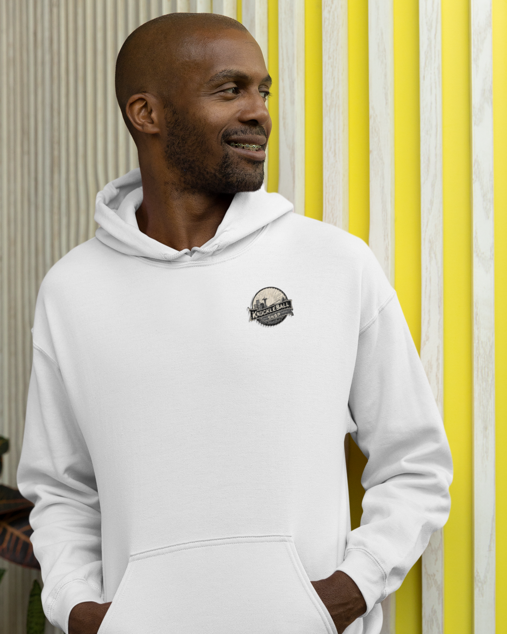 Man wearing a white hoodie with a logo against a striped background