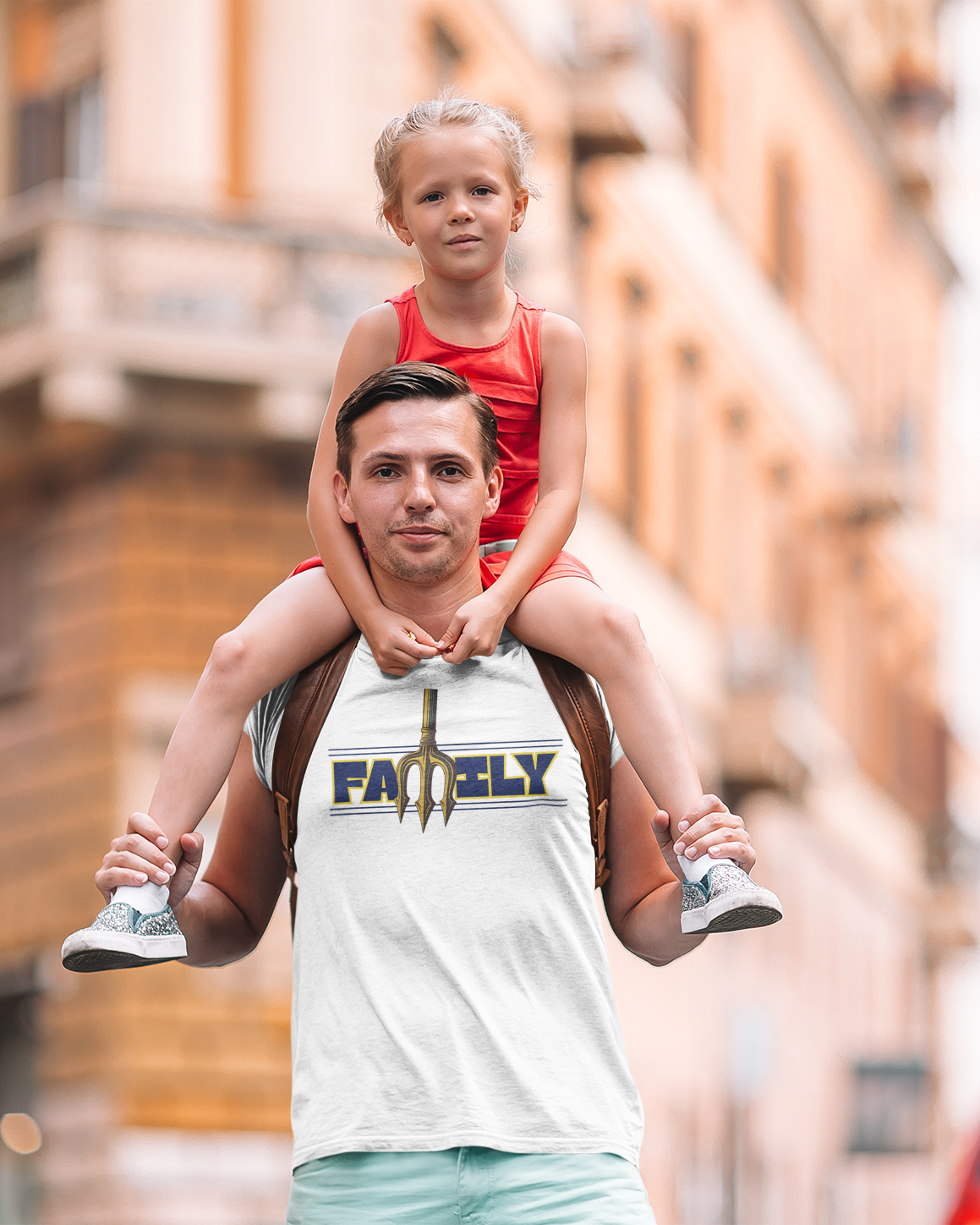 Man carrying a child on his shoulders in an urban setting